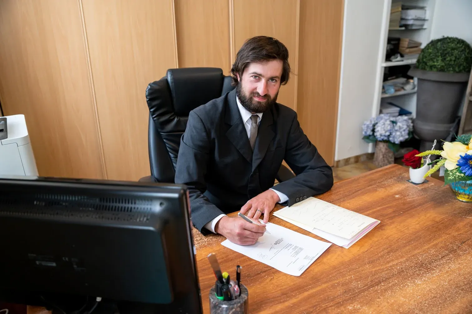 Conseiller funéraire assis à son bureau en train de remplir des documents officiels.